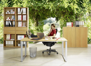 Sehr entspannt Frau (Füße auf dem Tisch) in einem Büro mit Bäumen im Hintergrund. Copyright: memo AG
